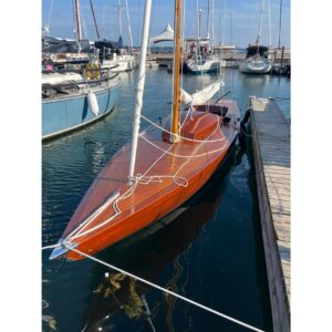 Vintage 1957 Dragon 29 sailboat docked in a marina, showcasing elegant wooden design.